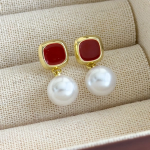 Détail des boucles d'oreilles vintage françaises en émail doré avec perles blanches