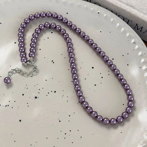 Dettaglio collana di perle di vetro lavanda con chiusura argento su vassoio in ceramica