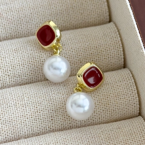 Détail de la boucle d'oreille rétro en émail carré avec une perle ronde et lustrée