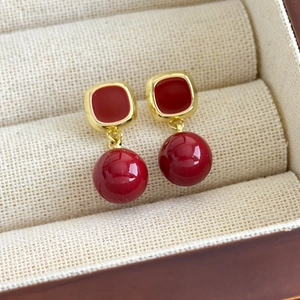 Détail de boucles d'oreilles rétro françaises avec émail rouge carré et perle