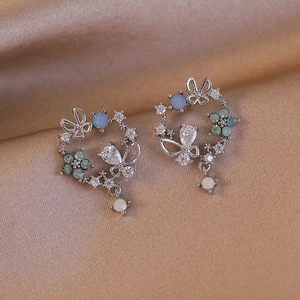 Macro detail of镂空 floral earrings with zirconia butterfly and opalescent bead drops