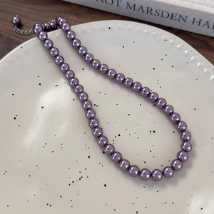 Vista dettagliata della collana di perle di vetro viola con chiusura e catena in argento
