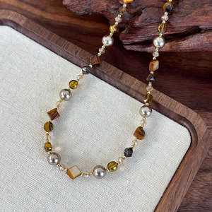 Détail du collier en oeil de tigre et perles montrant des perles marron et accents dorés