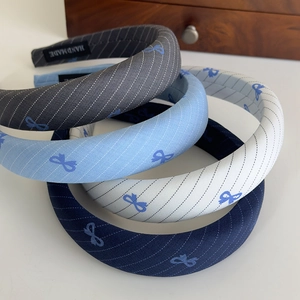 Macro shot of striped sponge headbands with blue bow patterns and handmade label detail