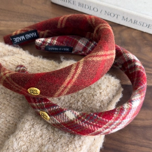 Detailed macro view of vintage red plaid fabric headbands with golden handmade metal plate
