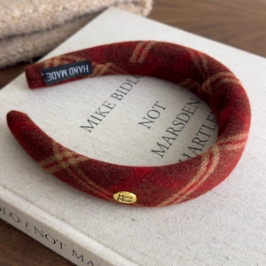 Detail of red plaid sponge headband with Hand Made label and gold metal tag