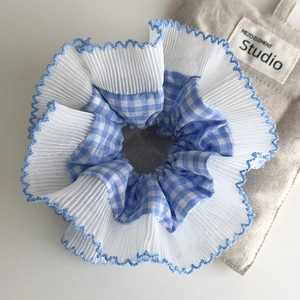 Primer plano detallado de coletero a cuadros azules con encaje blanco y borde azul