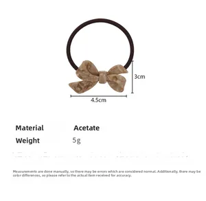 Detail view of brown acetate bow hair tie showing marble texture and 4.5cm size