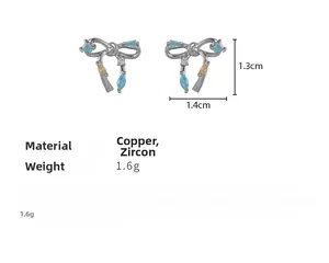 Détail de boucles d'oreilles nœud argenté avec zircon bleu et dimensions incluses