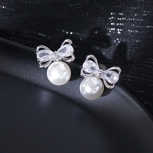 Exquisite silver bow stud earrings with sparkling zircons and elegant white pearls