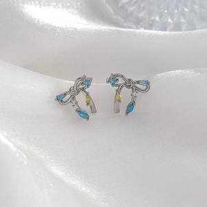 Boucles d'oreilles nœud en argent avec zircons bleus et accents de pierres fines