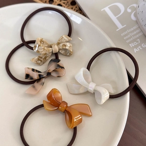 Close-up of four-piece ribbon acetate bow hair ties in marble and tortoiseshell patterns