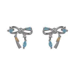 Boucles d'oreilles nœud élégantes en argent avec zircon bleu sur fond blanc neutre