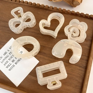 6-piece cream white camellia and bow hair claw clip set on a wooden tray