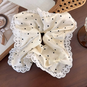 Chouchou à pois avec bordure en dentelle blanche et noeud sur fond de style rétro