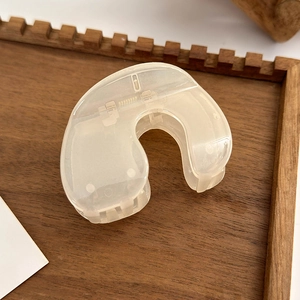 Close-up of a cream-colored resin hair claw clip showing the durable internal metal spring