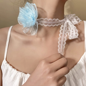 Detail of white lace choker with a light blue camellia flower and ribbon bow tie