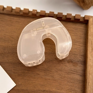Detail view of a translucent nude camellia claw clip on a warm wooden tray background