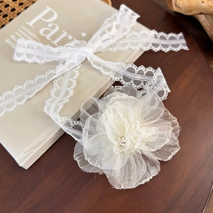 Detailed macro view of cream lace camellia flower choker with pearl stamen and mesh ribbon