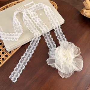 Detailed macro shot of white lace flower choker used as an elegant hair accessory ribbon