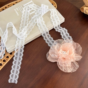 Close-up of elegant lace choker with organza camellia flower and pearl details