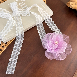 Detailed lace choker with purple organza flower and pearl on vintage book background