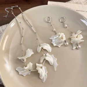 Elegant silver necklace and earring set with natural shell charms and white pearls