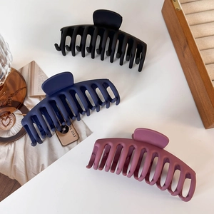Detailed view of matte large shark hair claws in black, navy, and dusty pink finishes