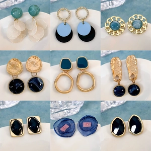 Set di nove orecchini con motivi floreali e geometrici blu dal design elegante