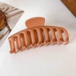 Close-up of large matte orange hair claw clip with strong teeth for thick hair