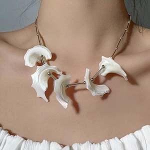 Close-up of shell-style necklace with silver chain and white organic curved pendants