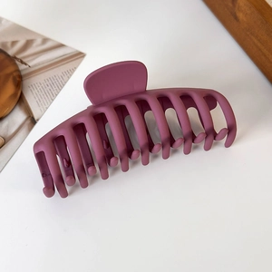 Macro detail of extra large matte dark purple hair claw clip with non-slip teeth texture