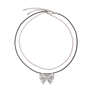 Double-layer silver bow necklace featuring pink beads and black cord on white background