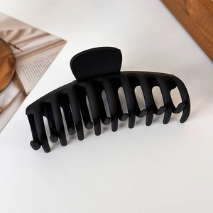 Close-up of a large matte black hair claw clip with non-slip frosted texture for long hair
