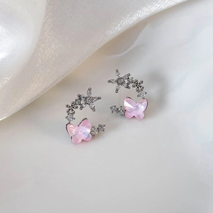 Macro shot of silver butterfly stud earrings with pink iridescent petals and small zircons