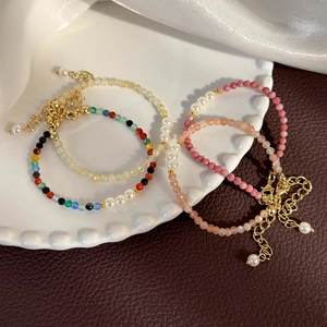 Colorful crystal pearl beaded bracelets set with gold lobster clasp in ceramic dish