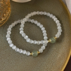 Bracelets en perles d'œil de chat avec accents verts sur une assiette en céramique