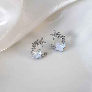 Detailed close-up of opal butterfly wings and zircon star flower earrings in silver setting