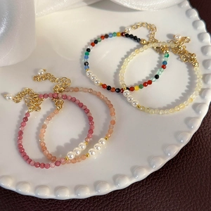 Set of four colorful crystal bead bracelets with white pearls and gold extension chain