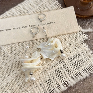 Detailed view of elegant silver drop earrings with white pearls and shell resin petals