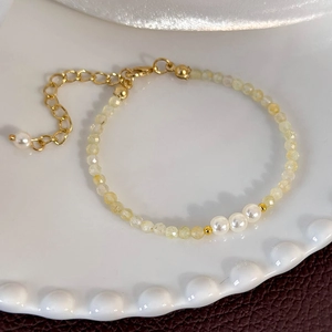 Detail of yellow crystal beaded bracelet with white pearls and gold lobster clasp