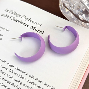 Dettaglio di orecchini a C viola opaco su un libro per una vista stile di vita