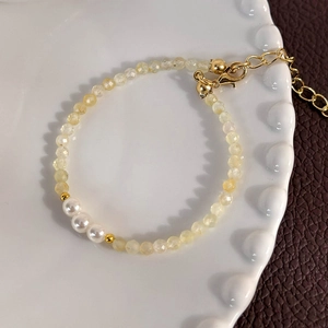 Detailed macro view of yellow faceted beads and white pearls on an elegant beaded bracelet