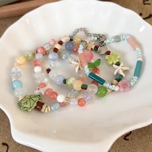 Colorful summer beaded bracelets with coconut tree and starfish charms on a white plate