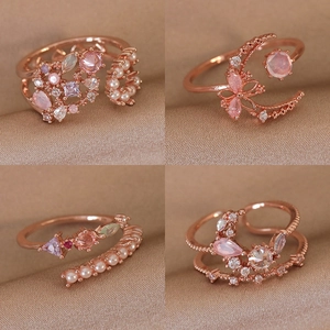 Detail of rose gold adjustable rings with pink zircon flowers and pearls on silk