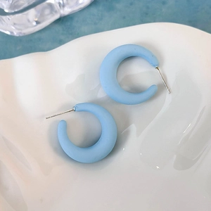 Dettaglio orecchini a C blu opaco con perni in argento S925 su vassoio bianco