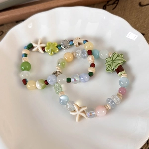 Close-up of summer ocean theme ceramic beaded bracelets with coconut tree and starfish charms