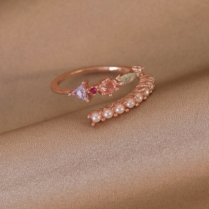 Macro detail of rose gold open ring with colorful zircons and delicate pearl row