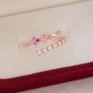 Detail of adjustable rose gold ring with colorful gemstones and white pearls in box