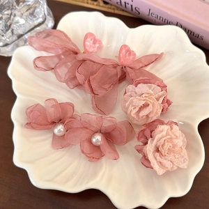 Ensemble barrette fleur en mousseline rose et élastique perle sur plateau coquille